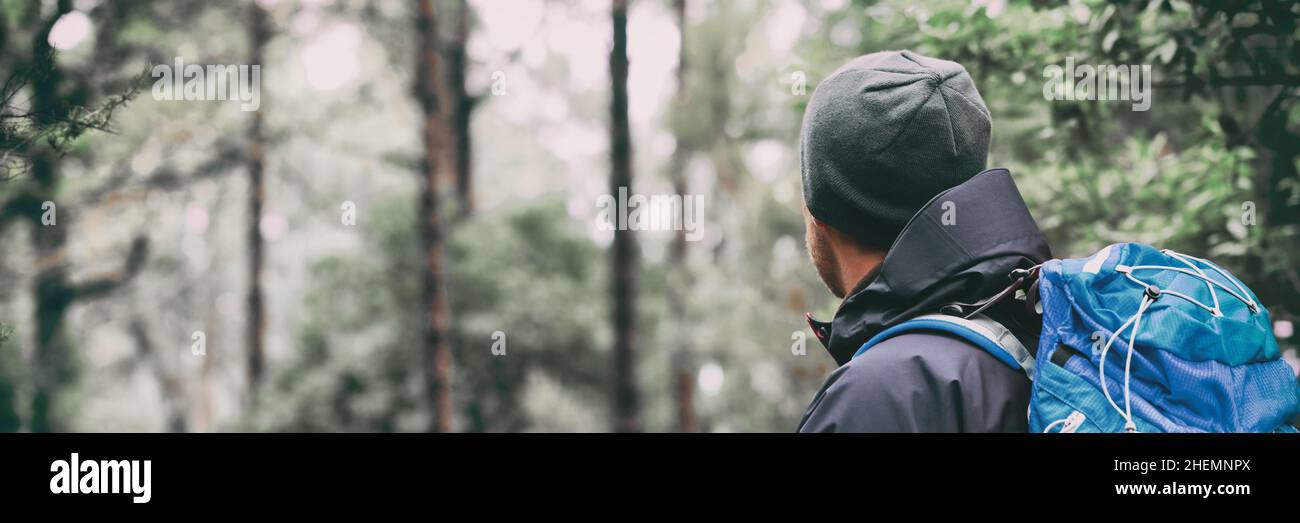 Wanderer, der im Winterwald durch Wälder spaziert. Wandern Outdoor Sport aktiven Lebensstil. Blick vom Rücken tragen Rucksack Stockfoto