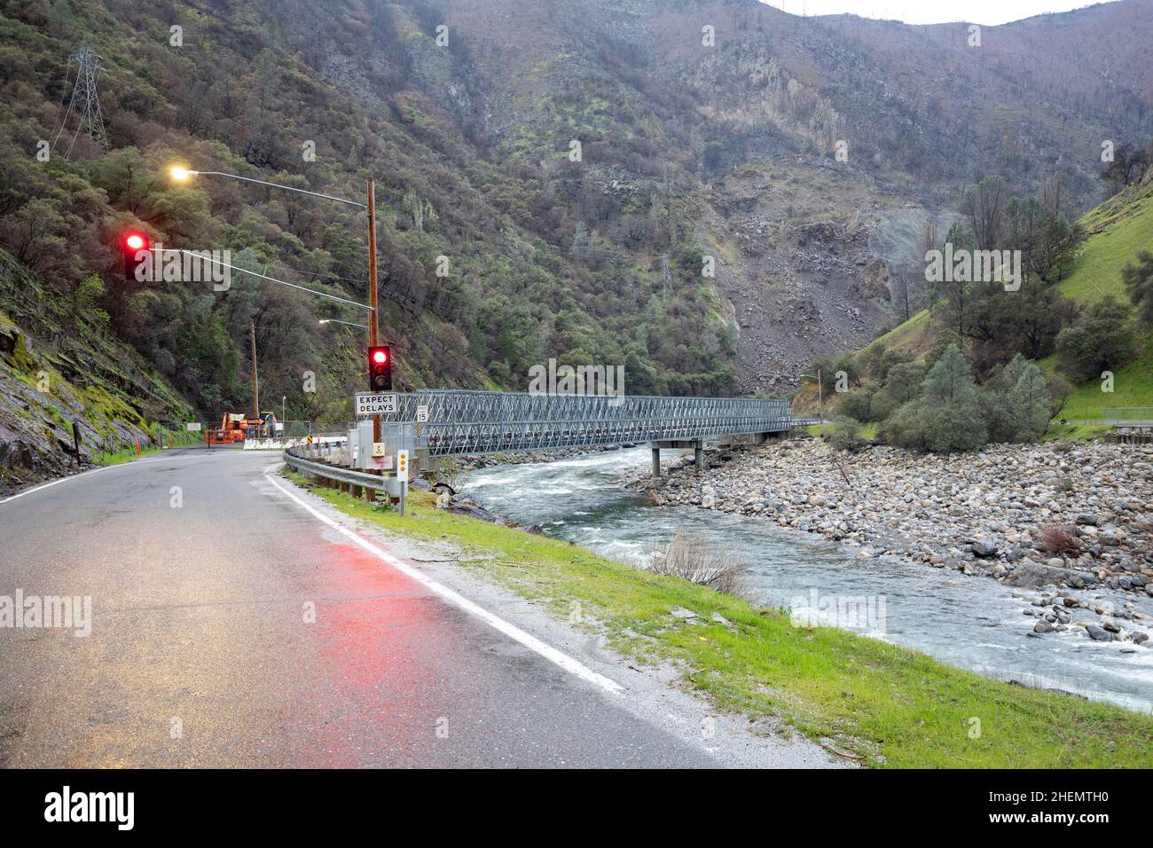 Baustelle an einer Straße mit rotem Verkehrslärm im yosemite Nationalpark bei schlechtem Wetter mit Flussbrücke über den Mariposa Creek, USA Stockfoto