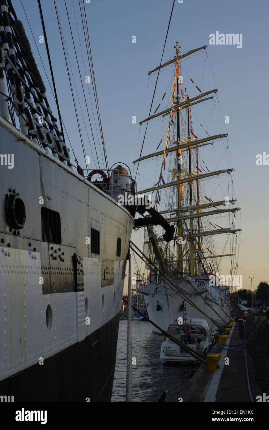 Hohe Schiffe vertäuten bei Sonnenuntergang in einem Hafen Stockfoto