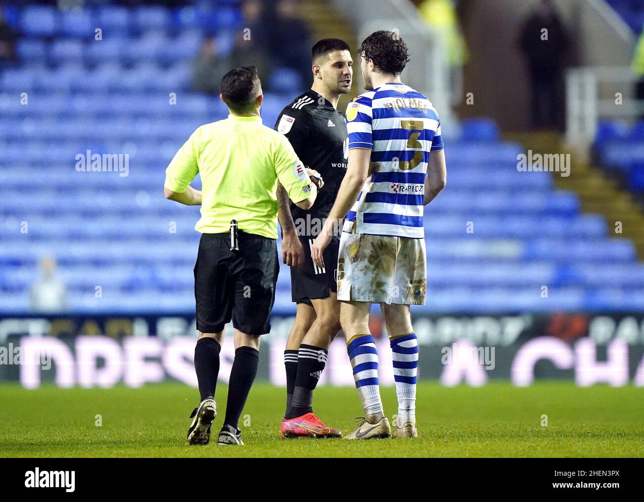 Fulhams Aleksandar Mitrovic und Reading's Tom Holmes (rechts) treffen aufeinander, als Schiedsrichter Tony Harrington während des Sky Bet Championship-Spiels im Select Car Leasing Stadium, Reading, versucht, einzutreten. Bilddatum: Dienstag, 11. Januar 2022. Stockfoto