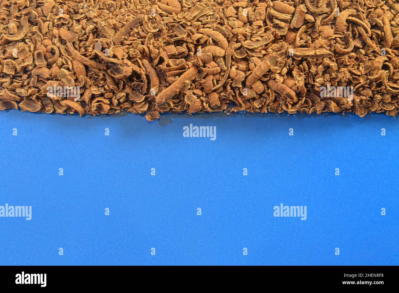 Textur von Milchschokolade-Schabraken. Gemahlener Schokoladenhintergrund. Verstreute geriebene Milchschokolade. Flach liegend und großer Kopierplatz. Schokoladenschnatschen auf Stockfoto