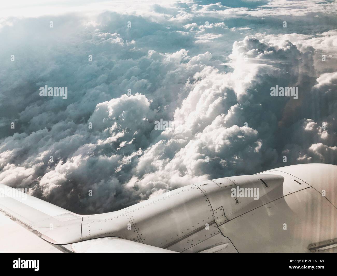 Blick auf den Himmel über den Wolken und den Flugzeugmotor. Aufnahme aus dem Flugzeugfenster. Stockfoto