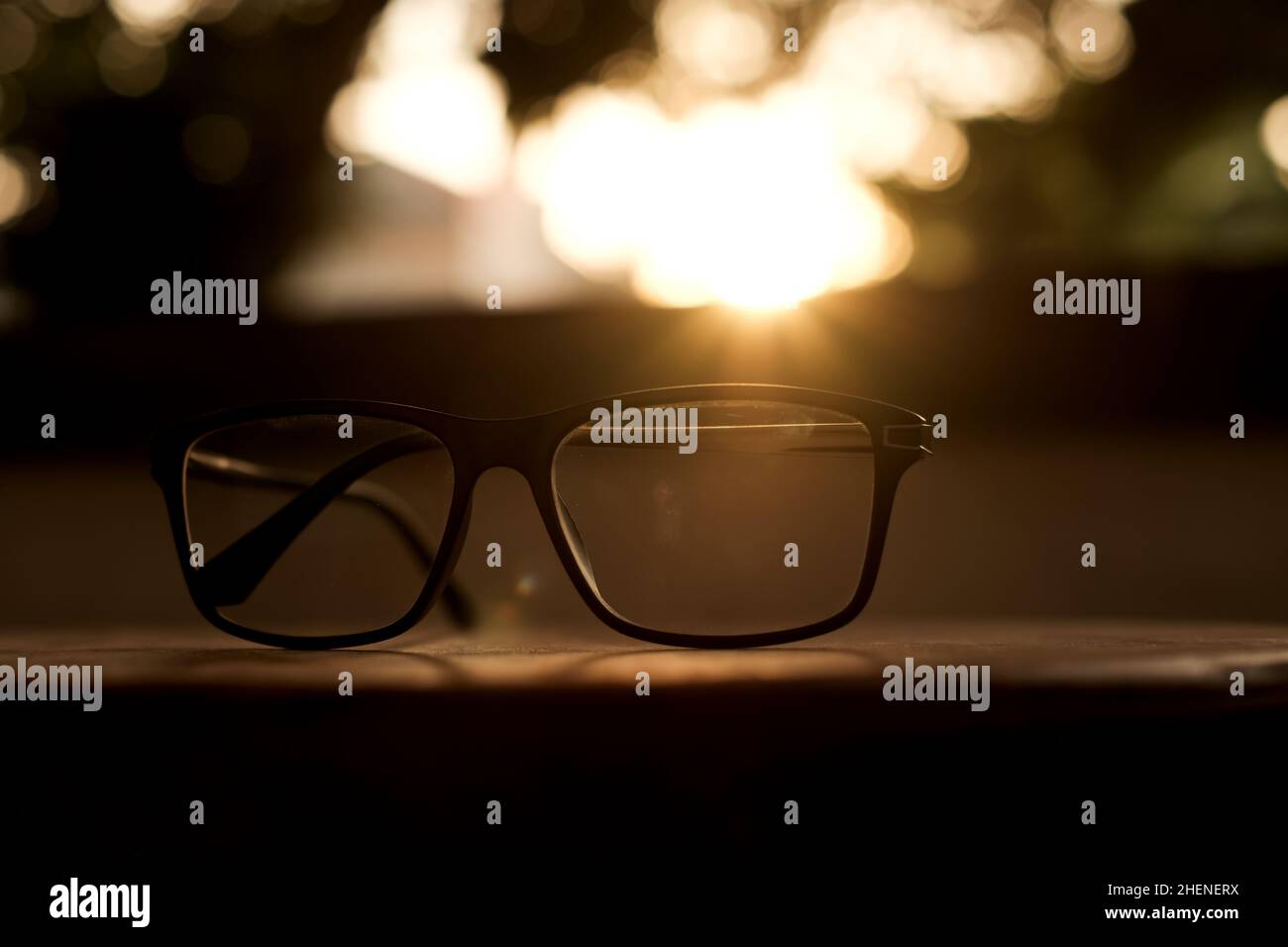 Moderner Stil. Sonnenbrille auf Holz mit sanftem Licht vom Sonnenuntergang. Stockfoto