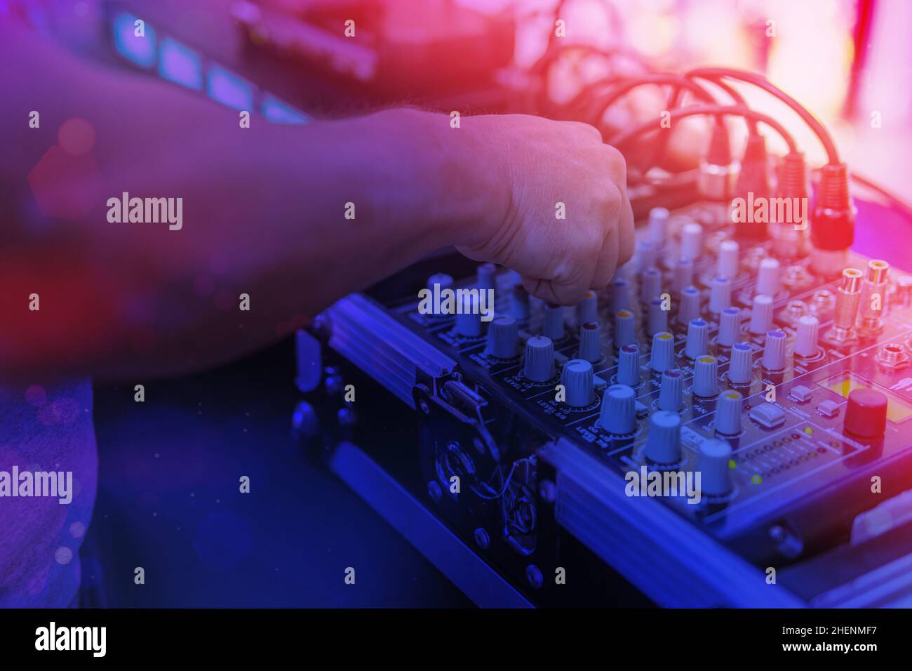 Hände eines djs, der die Musik auf einem Mixer steuert Stockfoto
