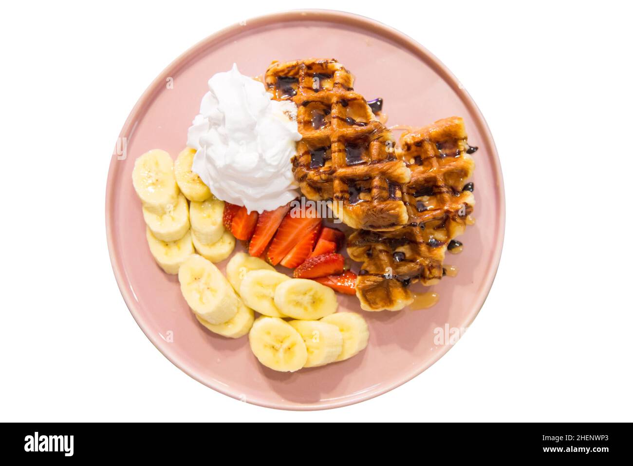 Draufsicht auf belgische Waffeln mit Schlagsahne und Bananenscheibe, Fokus selektiv Stockfoto