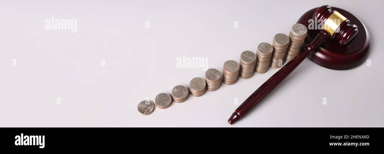 Hölzerner Richter-Gavel und Stapel von Münzen auf dem Tisch Stockfoto