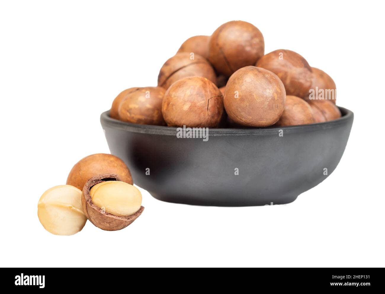 Macadamianüsse in Schale isoliert auf weißem Hintergrund Stockfoto