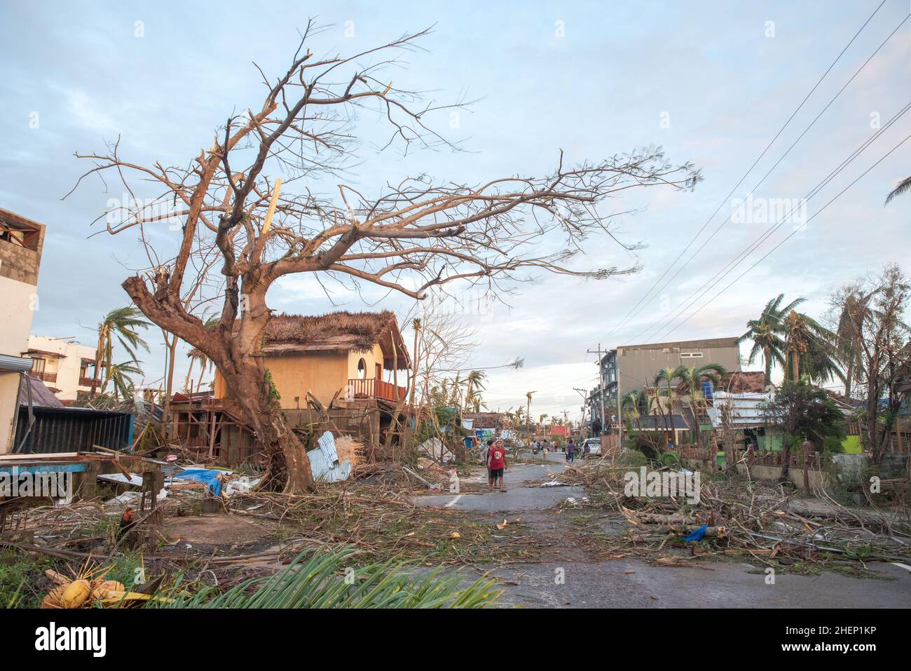Siargao Insel am Tag nach dem zerstörerischen Taifun Odette, zerbrochene Häuser, umgestürzte Kokosnusspalmen, traurige Menschen, Sonnenaufgang und Straßen voller Müll Stockfoto