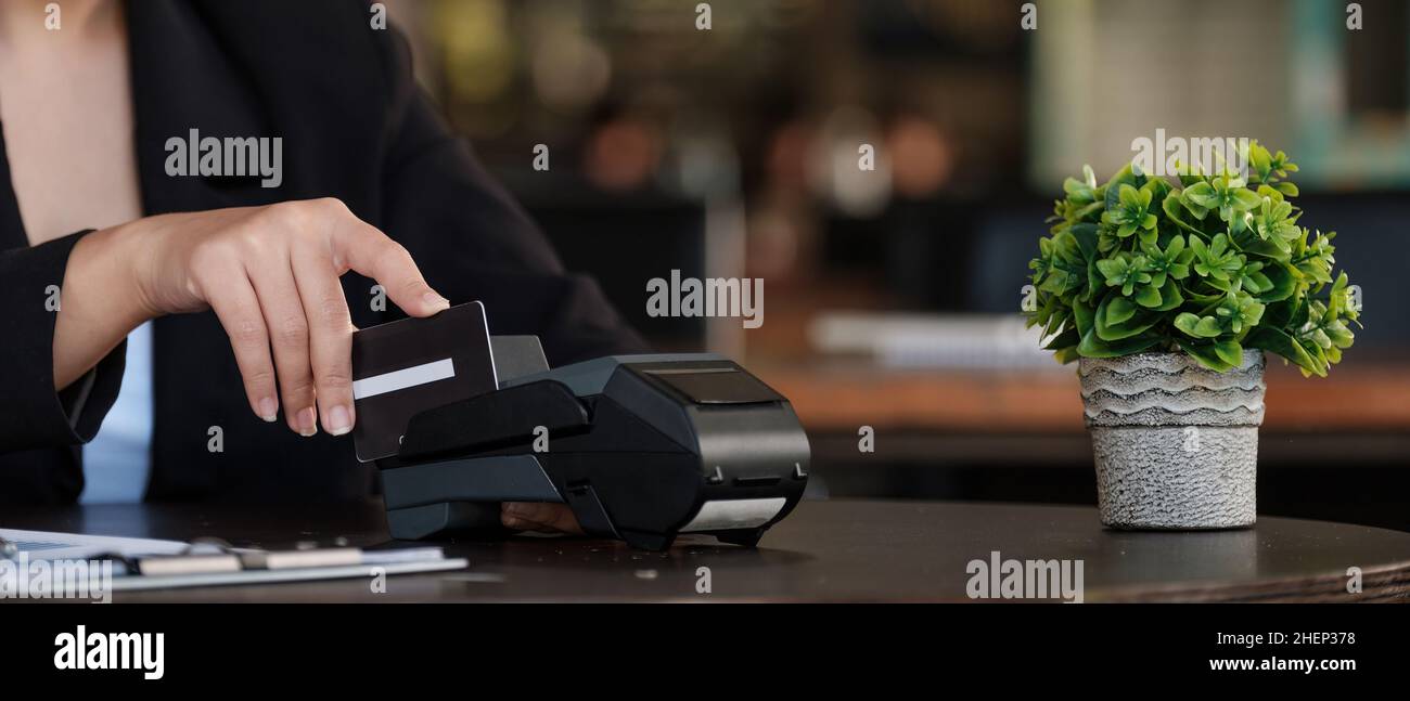 Geschäftsfrau Hand drücken Sie den Knopf und streichen Kredit auf Terminal stehen in Einkaufszentrum. Shopping und Retail-Konzept Stockfoto