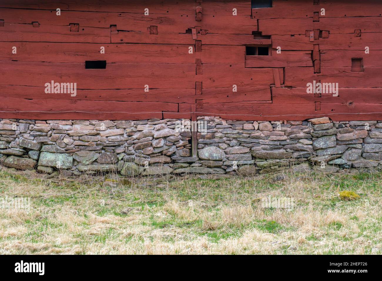 Alte rote Scheune mit Holzwerk auf einer Graswiese Stockfoto