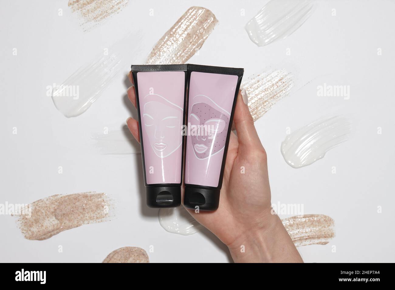 Plastikröhrchen mit Kosmetik auf Creme Striche Hintergrund Stockfoto
