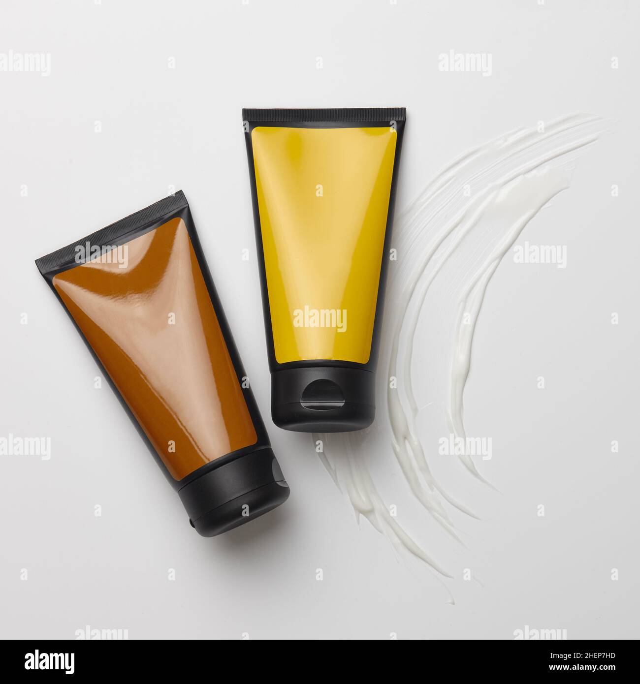 Farbige Kunststoffröhrchen mit weißen Cremetönen Stockfoto