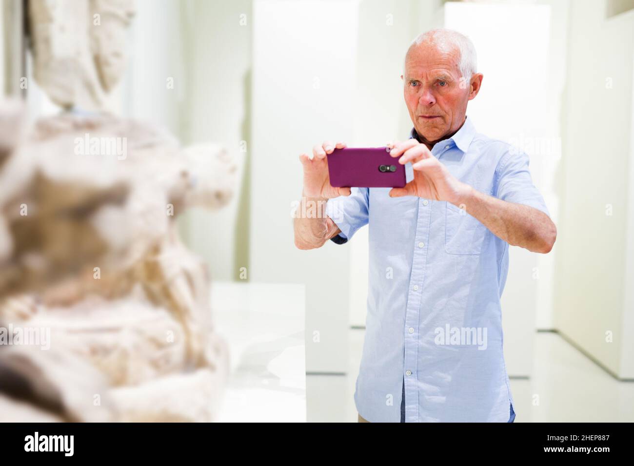 Mann fotografiert Skulpturen im Museum Stockfoto