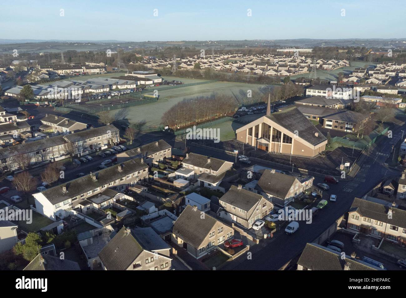 Cork, Irland. 12th Januar 2022. Frostiger Morgen in der Stadt Cork, Northside, Cork, Irland. Luftaufnahme der St. Olivers Kirche, der Spulen Oilibheir und der St. Aidans Seconday School in Ballyvolane mit einer Frostschicht am frühen Morgen. Die Menschen erwachten heute Morgen überall im Landkreis mit Frostdecken, weil die Temperaturen über Nacht unter den Gefrierpunkt gefallen waren. Kredit: Damian Coleman/Alamy Live Nachrichten Stockfoto