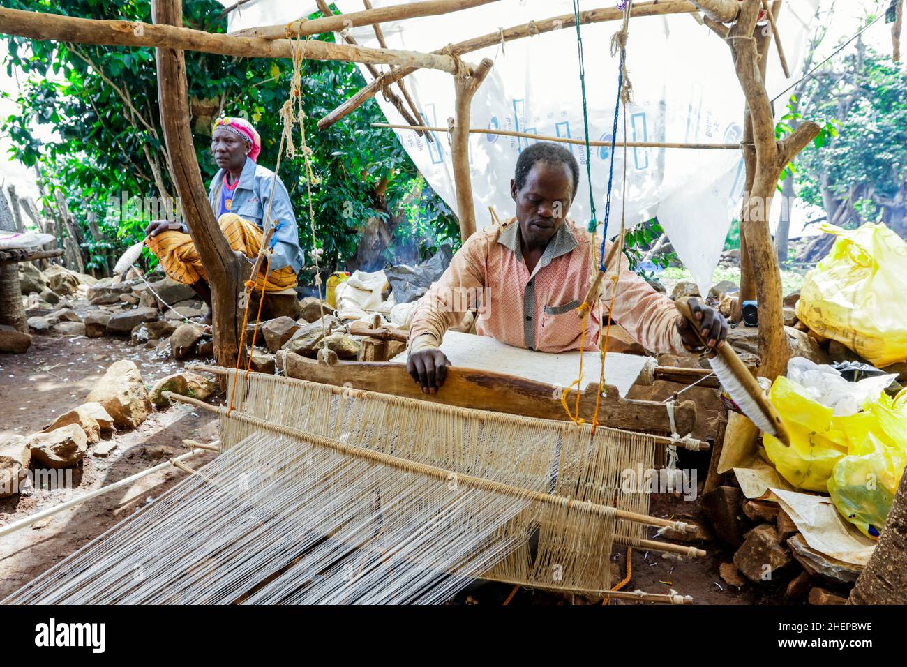 Afrikanischer Konso-Mann dreht sich mit den Händen auf dem Holzrad im lokalen Stammesdorf Stockfoto