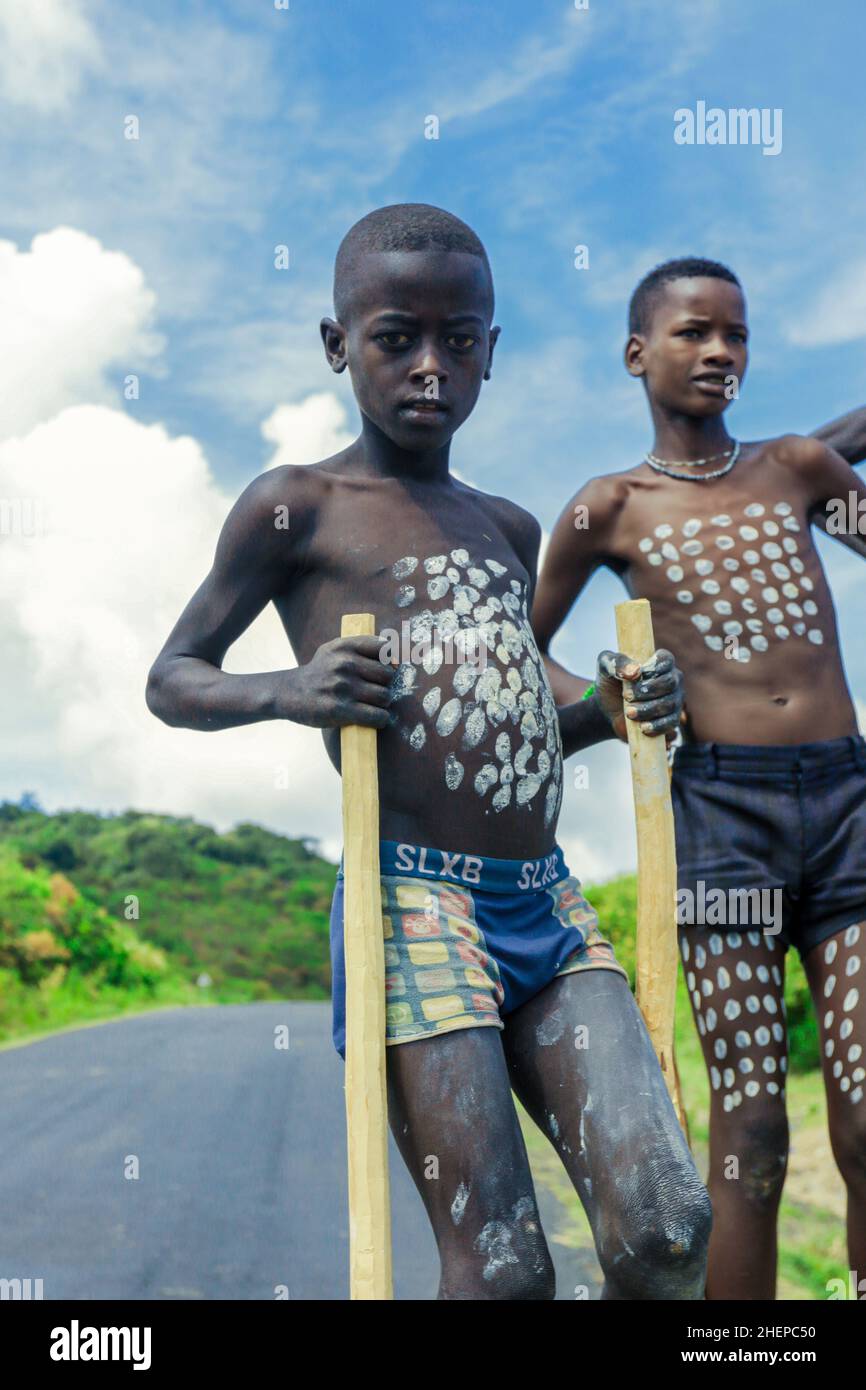 Nahaufnahmen von Benna Tribe Young Boys mit traditioneller Körpermalerei auf den langen Holzstäben Stockfoto