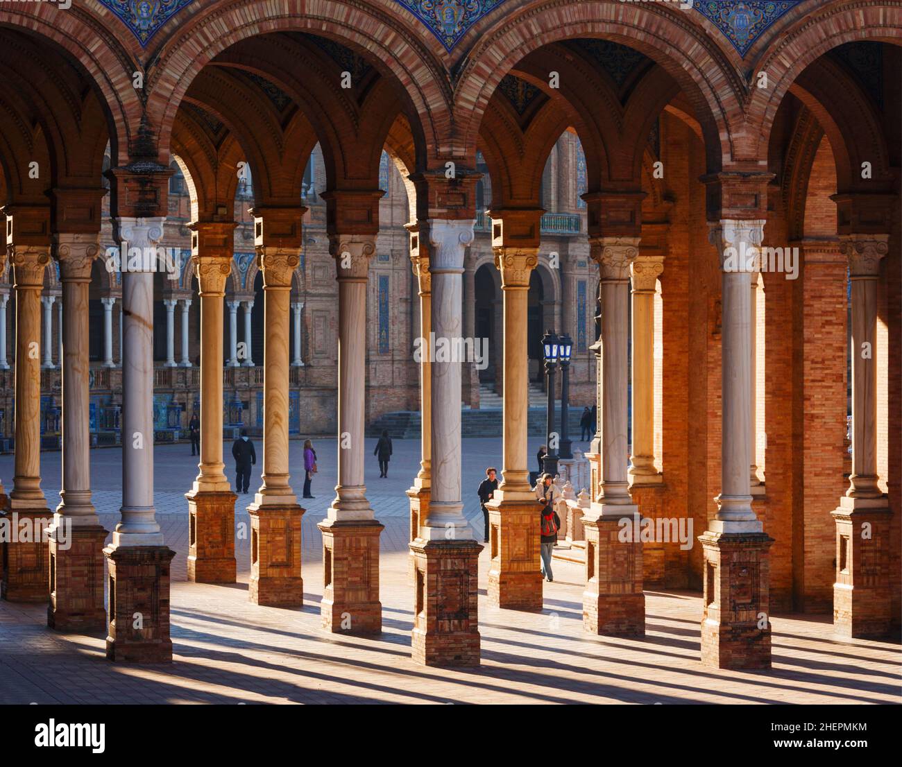 Sevilla, Provinz Sevilla, Andalusien, Südspanien. Touristen zwischen den Säulen und Bögen auf der Plaza de España. Die plaza wurde für die IB gebaut Stockfoto
