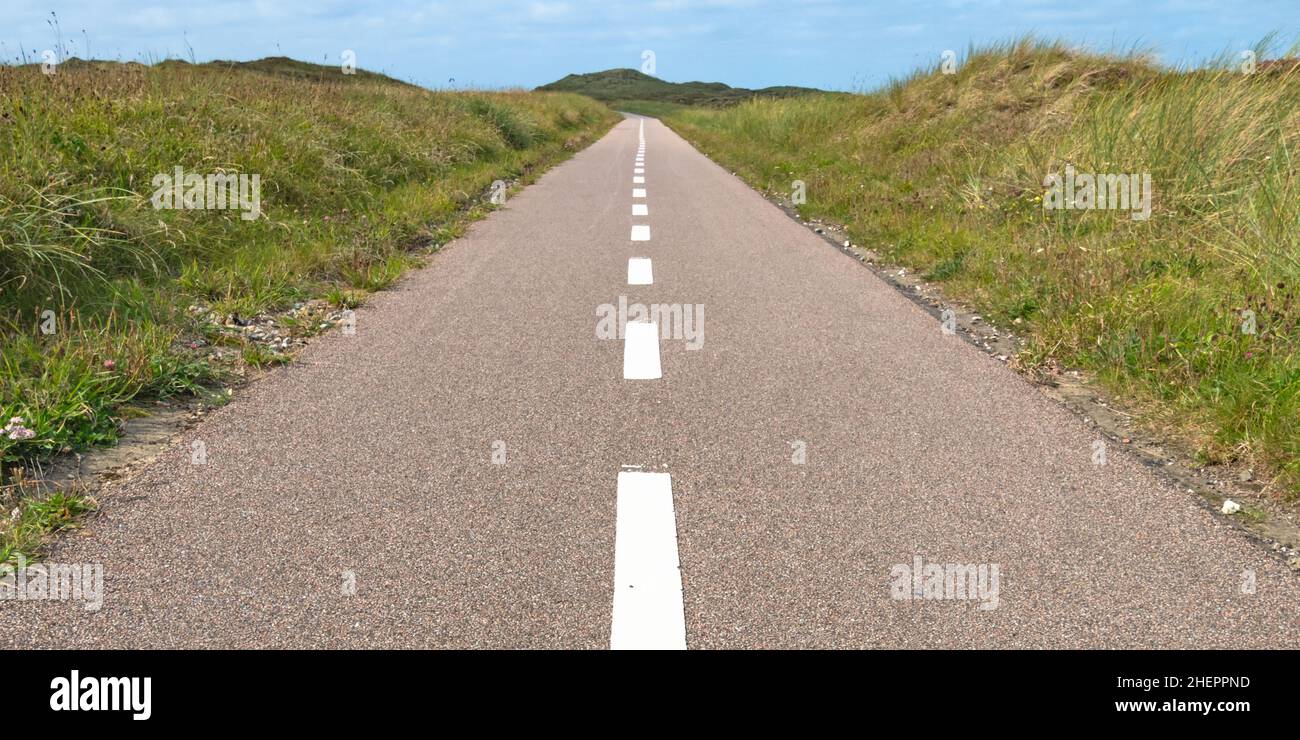 Eine gebrochene Linie Asphaltstraße führt durch die Dünen von Dänemark Stockfoto