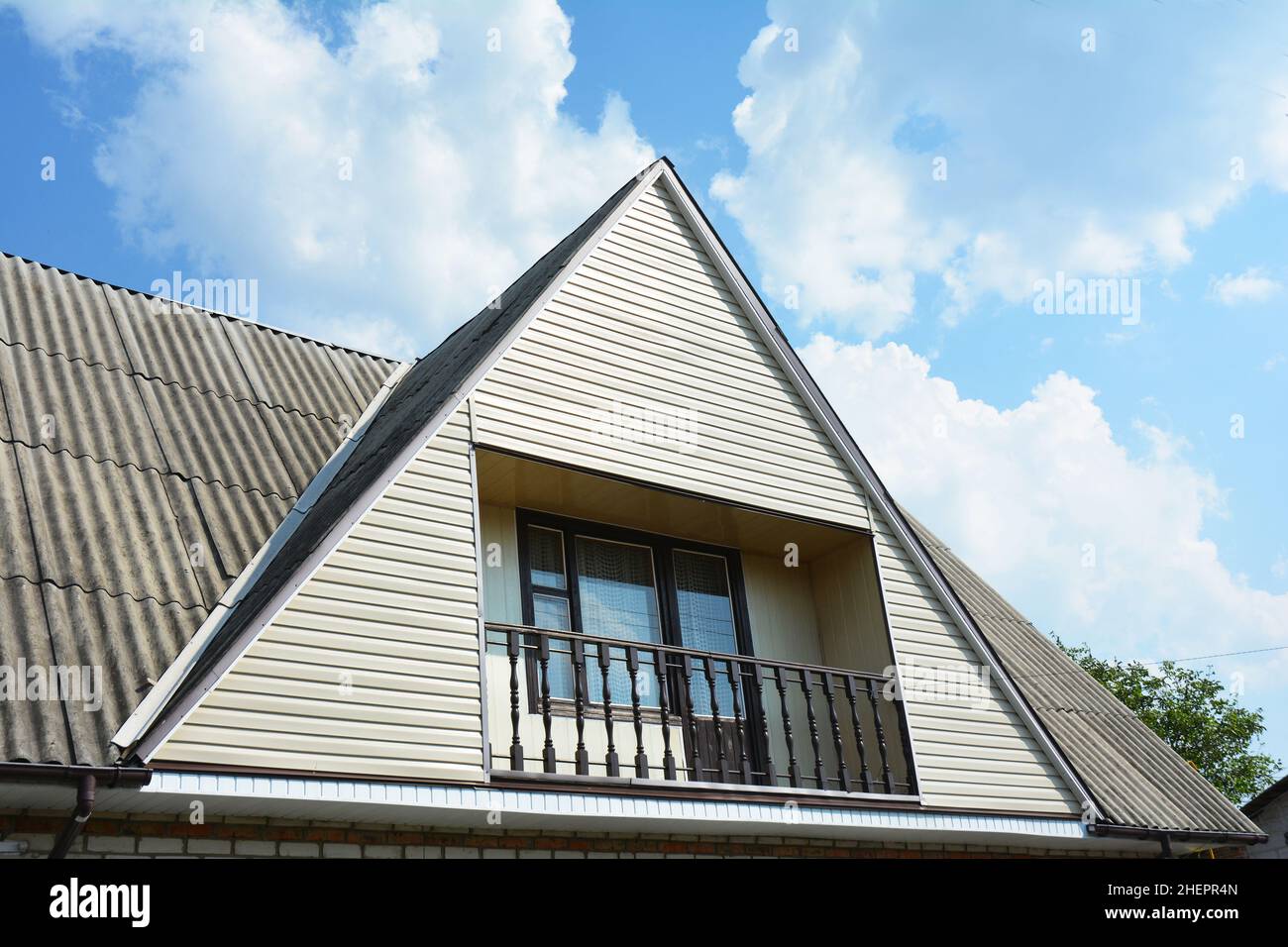 Giebel und Valley Dachkonstruktion mit gemütlichem Balkon. Gebäude Dachgeschosshausbau mit verschiedenen Arten von Dachkonstruktionen Stockfoto