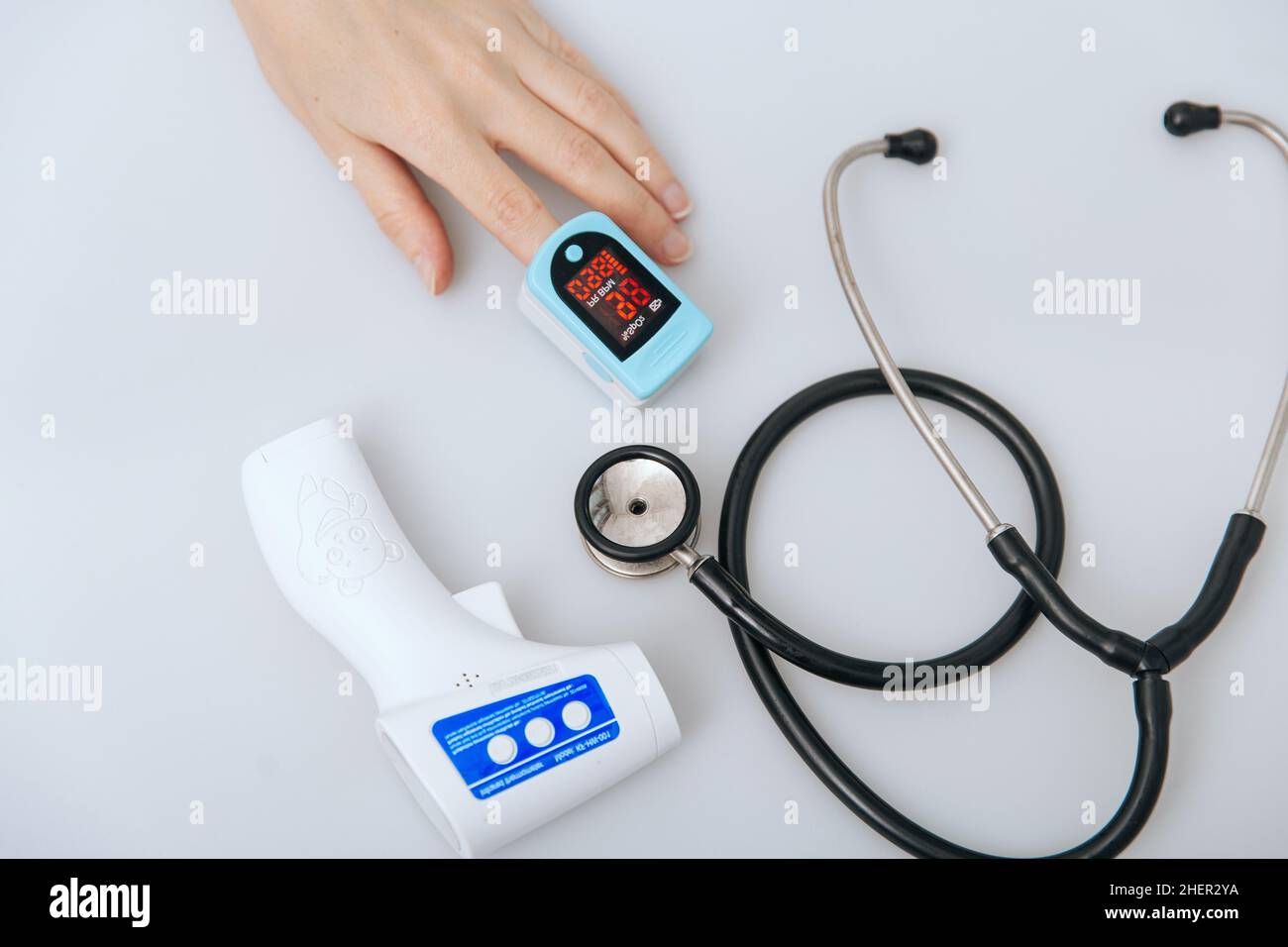 Stethoskop, Pulsoximeter und Thermometerpistole auf weißem Hintergrund. Behandlung von Erkältung oder Grippe. Phonendoskop. Infrarot-isometrisches Thermometer Pistole zu Stockfoto