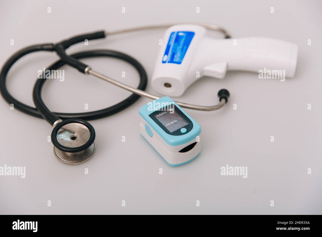 Stethoskop, Pulsoximeter und Thermometerpistole auf weißem Hintergrund. Behandlung von Erkältung oder Grippe. Phonendoskop. Infrarot-isometrisches Thermometer Pistole zu Stockfoto