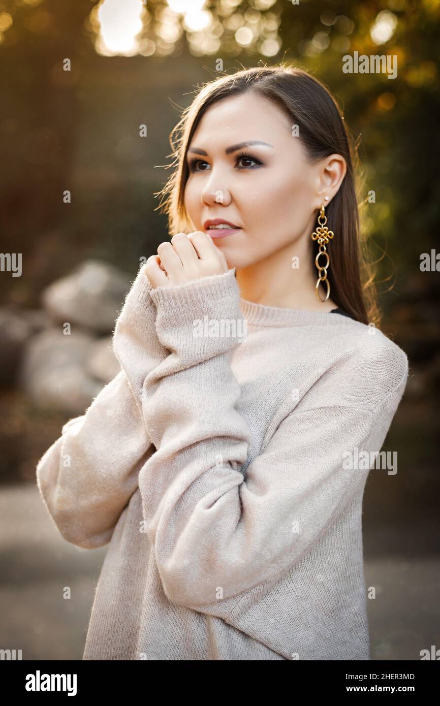 Nette junge Frau in einem Pullover im Herbstwald unter den Bäumen im Freien. Hochwertige Fotos Stockfoto