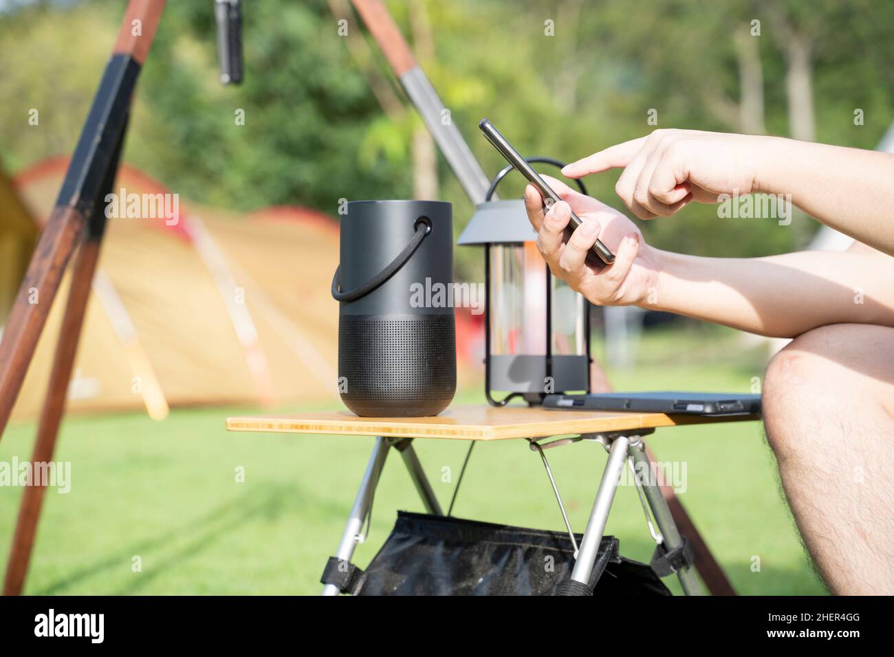 Männer, die einen Smart-Lautsprecher mit Smartphone verwenden. Stockfoto