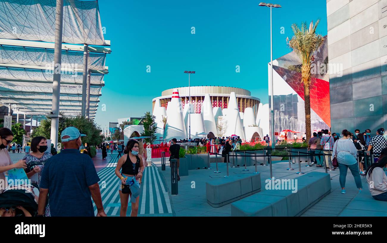 Menschen posieren vor dem Hintergrund der Pavillons von Österreich und der Schweiz auf der Expo 2020 Stockfoto