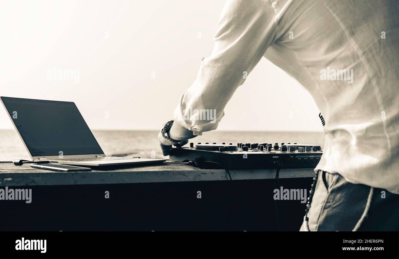 Discjockey spielt Musik für Touristen auf der Clubparty im Freien am Strand - DJ bei Musik-Live-Event - Live-Event, Musik und Fun-Konzept - Entert Stockfoto