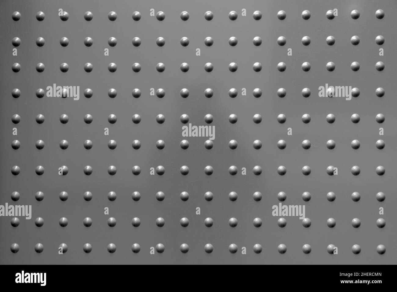Grauer harmonischer Hintergrund aus Metall mit Flecken in regelmäßigem Muster Stockfoto