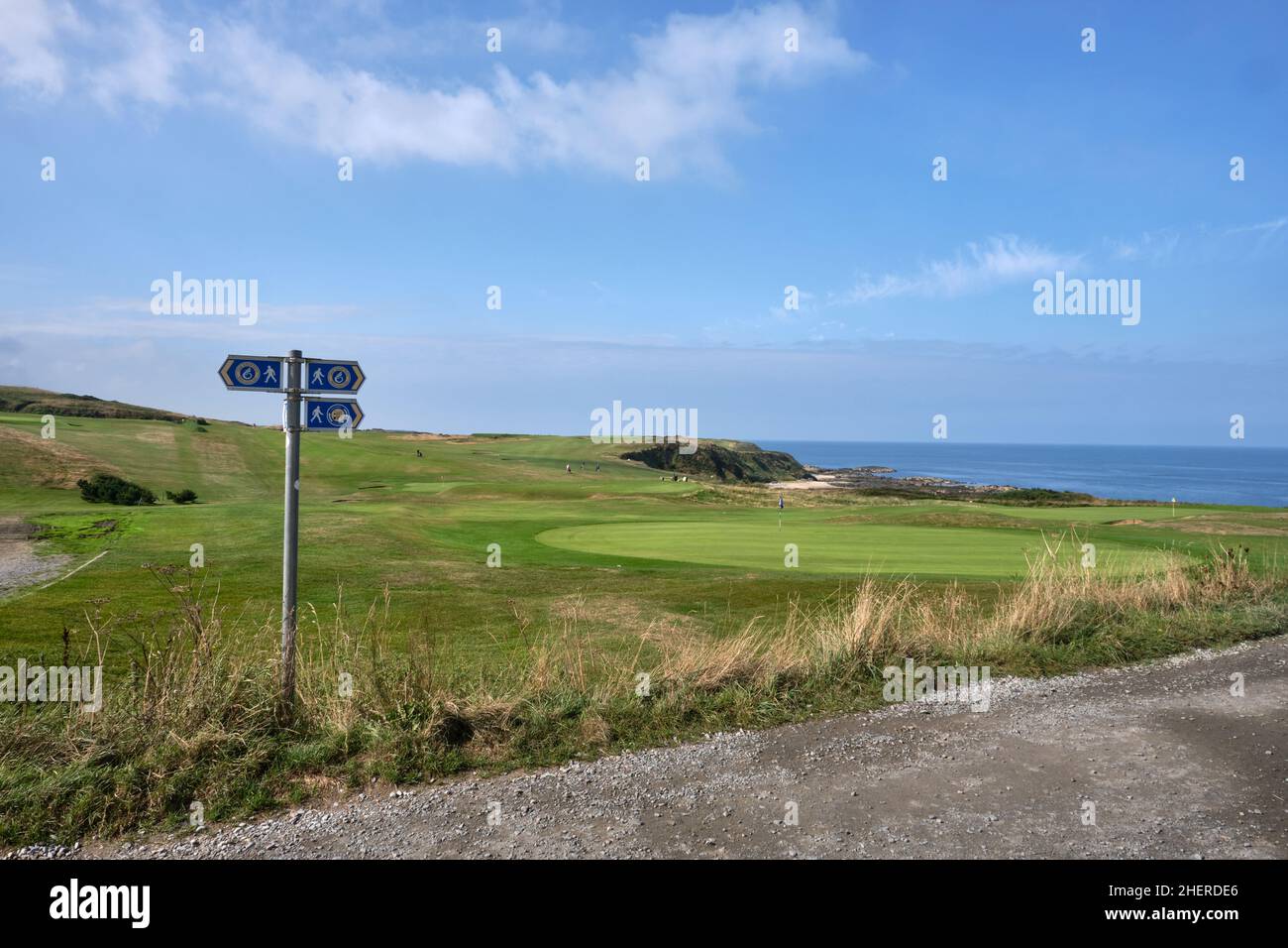 Ein Schild für den Wales Coast Path, der durch den Clwb Golff Nefyn Golf Club auf Porth Dinllaen führt. Stockfoto