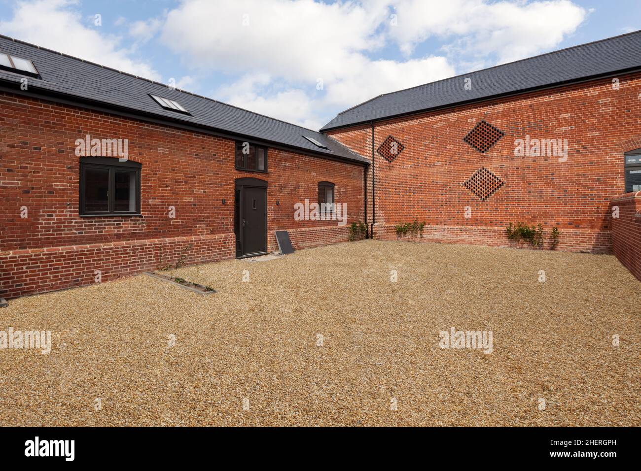 Cowlinge, Suffolk, England - 9. April 2019: Stilvoller Umbau der Scheune nach hinten mit weitläufiger Ziegelfassade, Schindelgärten, neuem Wind Stockfoto