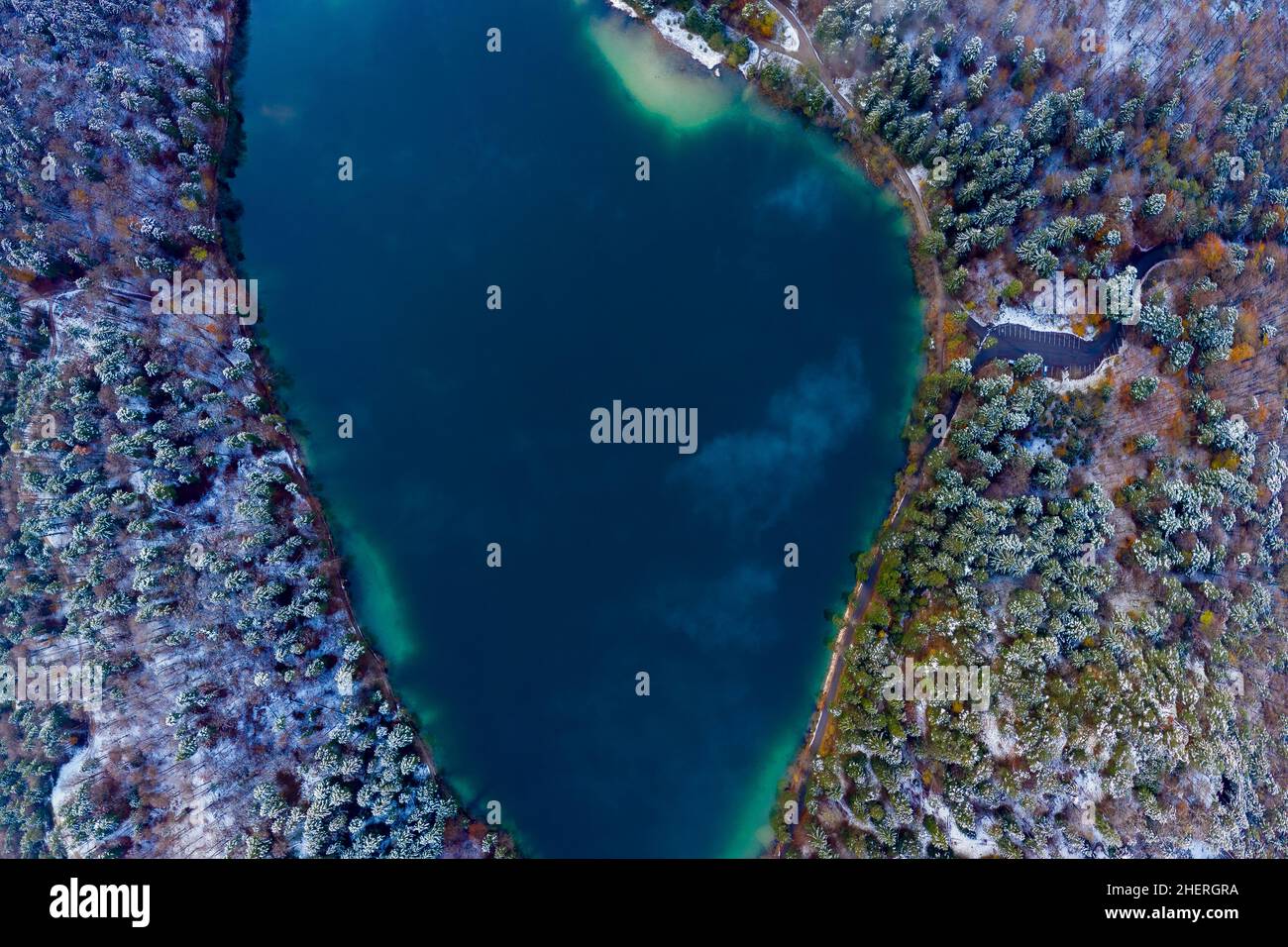 Luftaufnahme zum blauen Alatsee mit verschneiten Waldbäumen im Winter Stockfoto