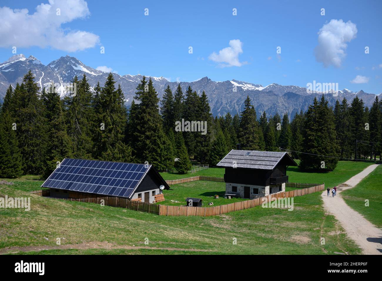 Nachhaltige Photovoltaikhäuser in den bergalpen am Wald mit blauem Himmel Stockfoto
