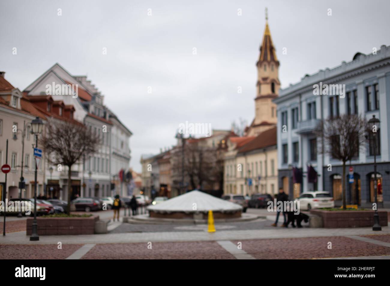 Verschwommener Hintergrund der europäischen Stadt Vilnius Altstadt. Asphaltierte Straße und Platz mit Leuten, die herumlaufen Stockfoto