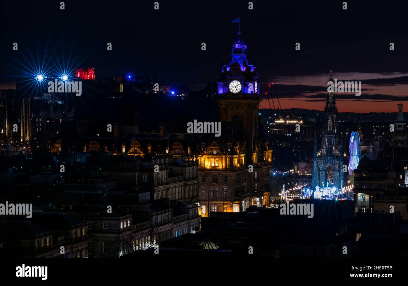Eine Lichtshow vom Edinburgh Castle aus, die bei Sonnenuntergang und weihnachtlichen Festlichtern über der Skyline der Stadt zu sehen ist, Edinburgh, Schottland, Großbritannien Stockfoto