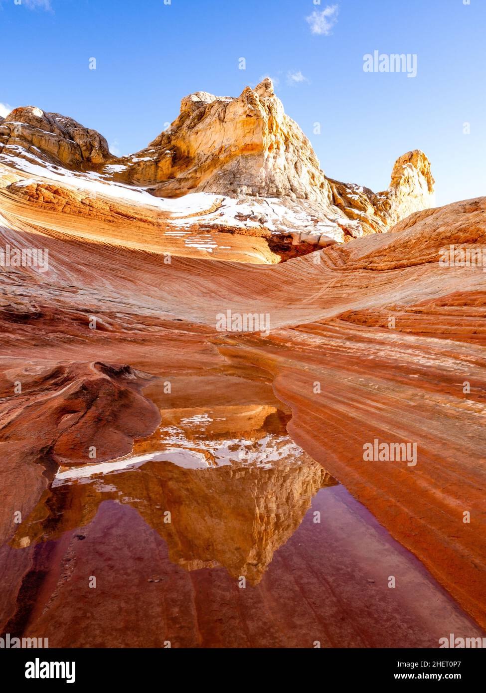 Schnee auf roten Felsen, der sich in einer Nische im White Pocket Area des Vermilion Cliffs National Monument, Arizona, spiegelte, ist ein seltenes Ereignis. Stockfoto