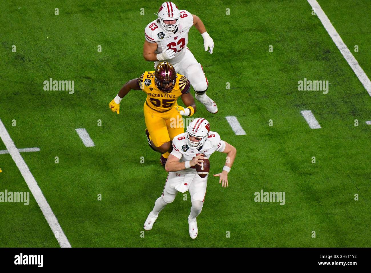 Graham Mertz (5), der Quarterback der Wisconsin Dachs, wird vom Verteidigungslineman B.J. der Sun Devils des Staates Arizona unter Druck gesetzt Green II (35) während des Las Vegas Bowl Stockfoto Graham Mertz (5), der Quarterback der Wisconsin Dachs, wird vom Verteidigungslineman B.J. der Sun Devils des Staates Arizona unter Druck gesetzt Green II (35) während des Las Vegas Bowl Stockfoto