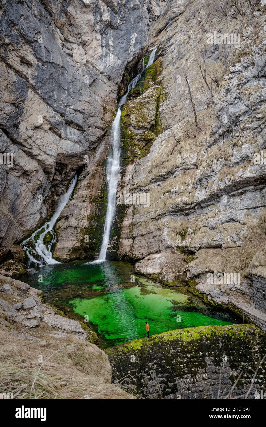 Ein Mädchen, das am Rande des Savica-Wasserfalls in Slowenien, am Bohinj-See und im Triglav-Nationalpark steht Stockfoto