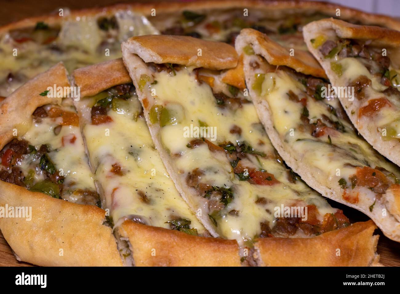 Türkische Pita mit Rindfleisch und Käse. Türkisches Pide mit Fleischkäse und Gemüse auf einem hölzernen Hintergrund Stockfoto