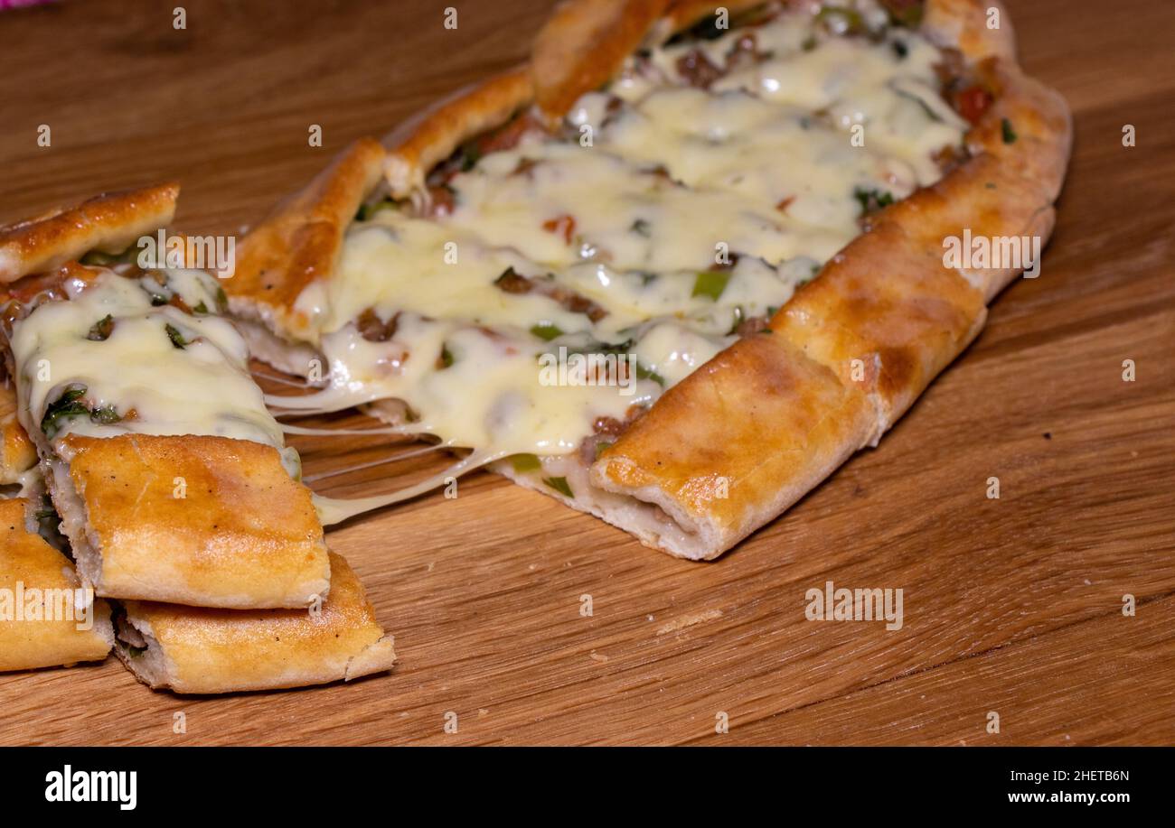 Türkische Pita mit Rindfleisch und Käse. Türkisches Pide mit Fleischkäse und Gemüse auf einem hölzernen Hintergrund Stockfoto