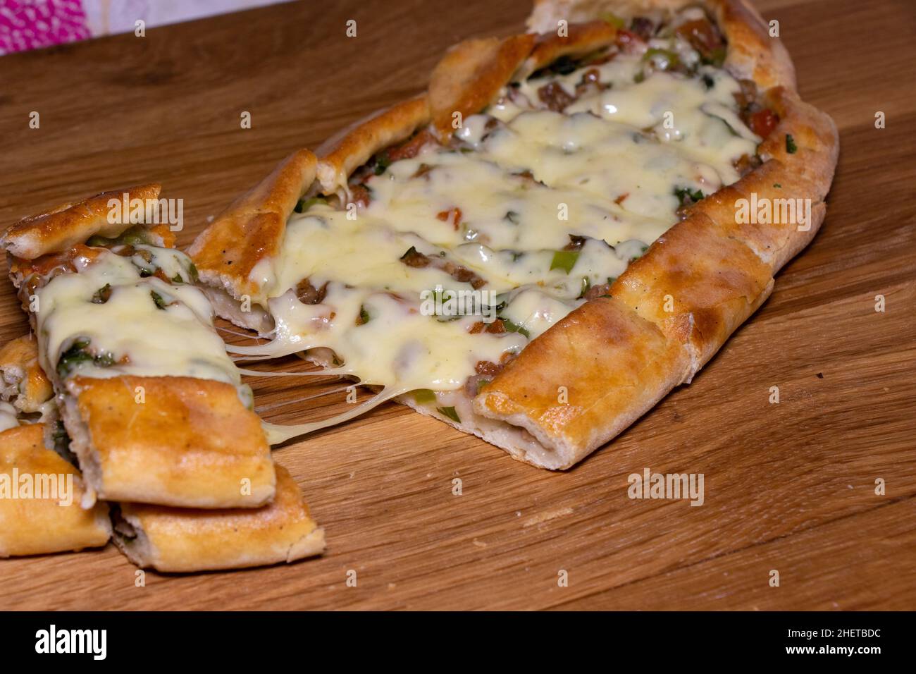 Türkische Pita mit Rindfleisch und Käse. Türkisches Pide mit Fleischkäse und Gemüse auf einem hölzernen Hintergrund Stockfoto