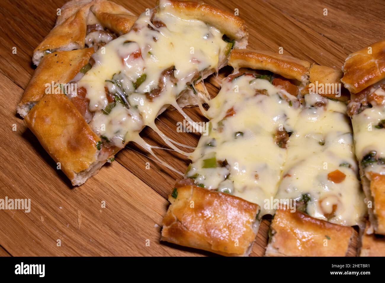 Türkische Pita mit Rindfleisch und Käse. Türkisches Pide mit Fleischkäse und Gemüse auf einem hölzernen Hintergrund Stockfoto