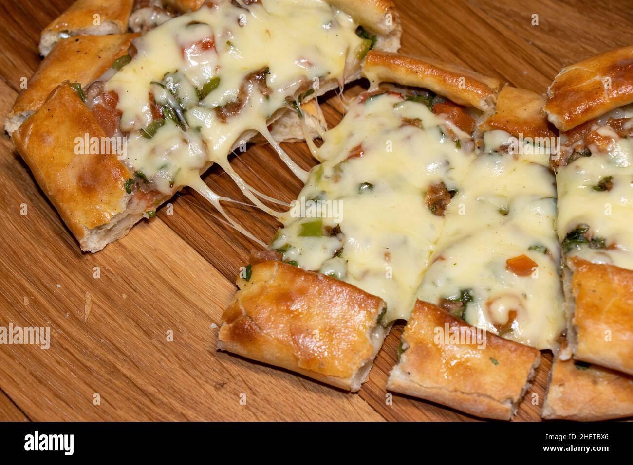Türkische Pita mit Rindfleisch und Käse. Türkisches Pide mit Fleischkäse und Gemüse auf einem hölzernen Hintergrund Stockfoto