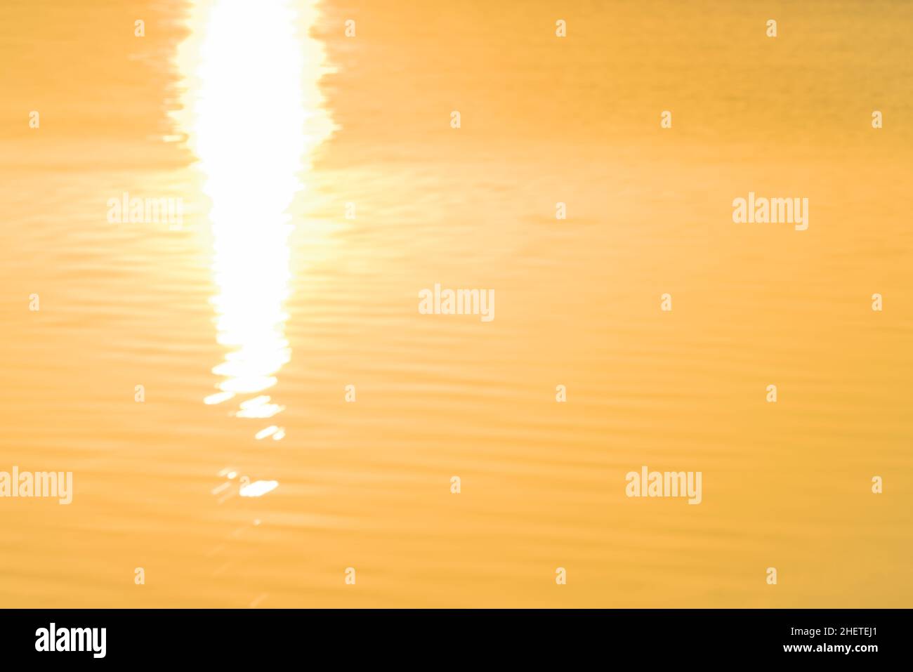 Weiche Wellen auf dem Wasser von sunrise Leuchten abstrakte goldenen Reflexen Hintergründe Bild beleuchtet. Stockfoto