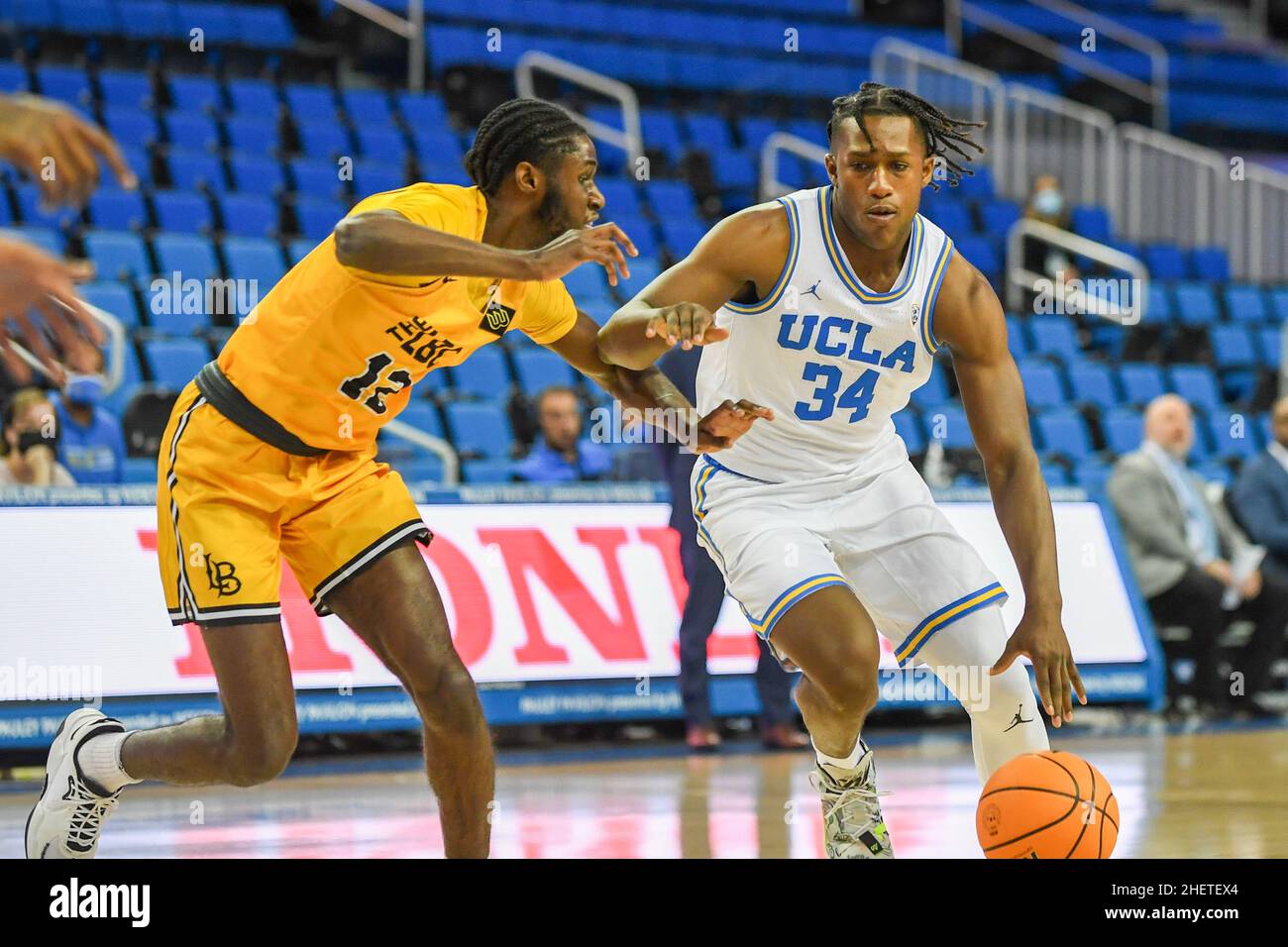 UCLA Bruins-Wächter David Singleton (34) dribbelt den Ball vom Long Beach State 49ers-Wächter Jadon Jones (12) während eines NCAA-Basketballspiels am Donnerstag ab Stockfoto