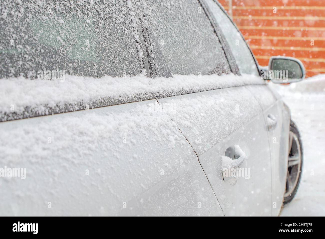 Gefrorener Rückspiegel, verschneites Auto. Winter, Schnee, Schneefall Stockfoto