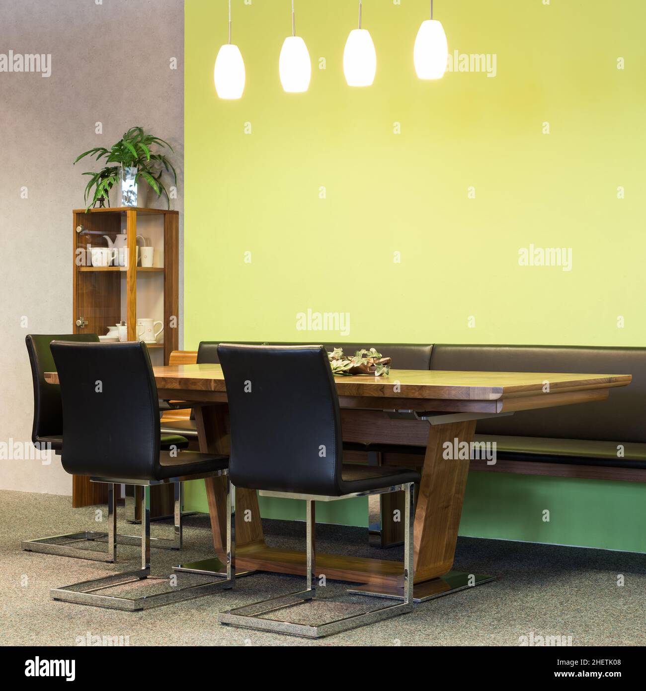 Blick auf Holztisch mit Lederstühlen im Speisesaal mit Beleuchtung Stockfoto