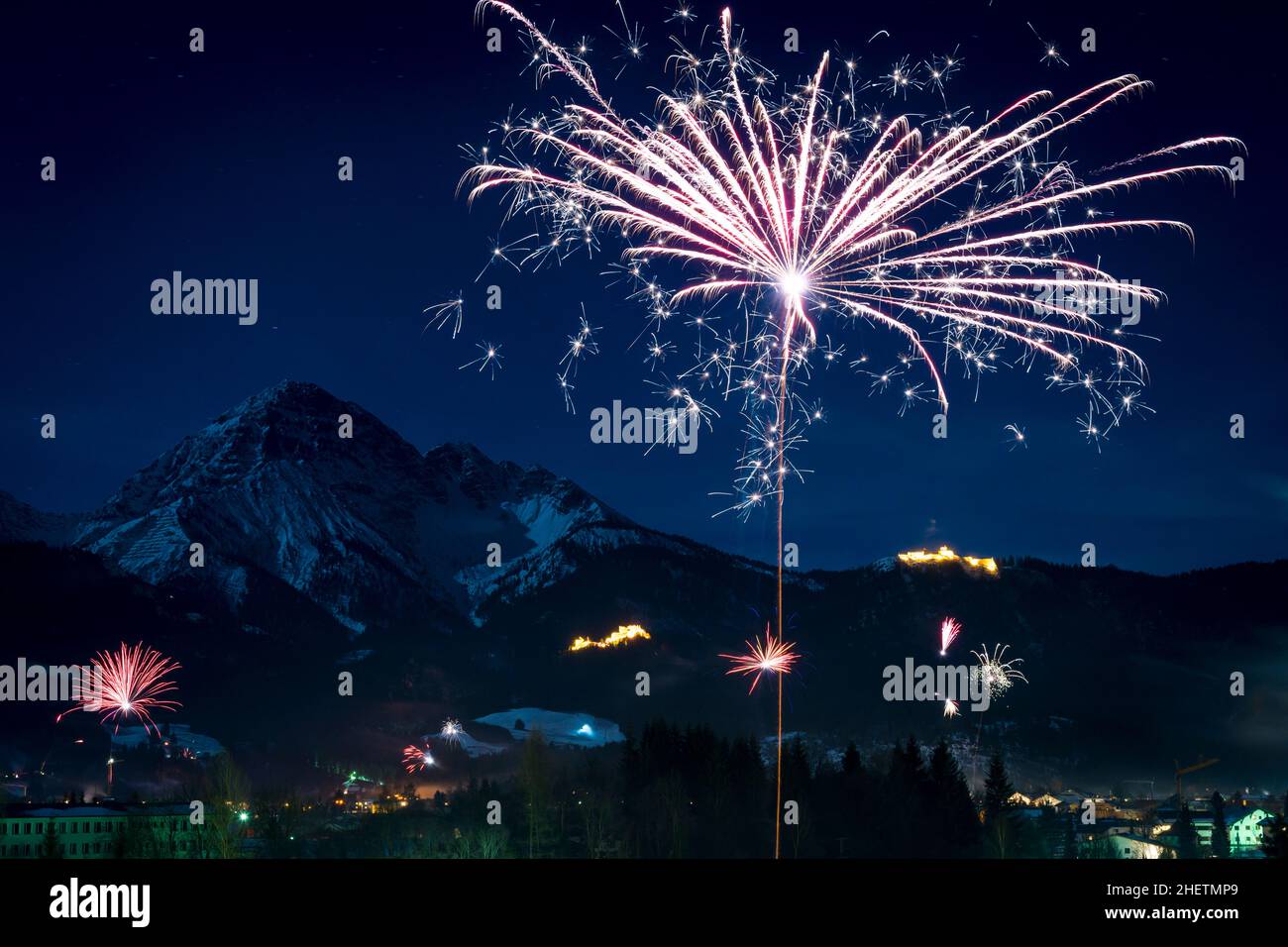 Silvesterfeuerwerk raketenartig nach oben fliegen vor den Bergen Stockfoto