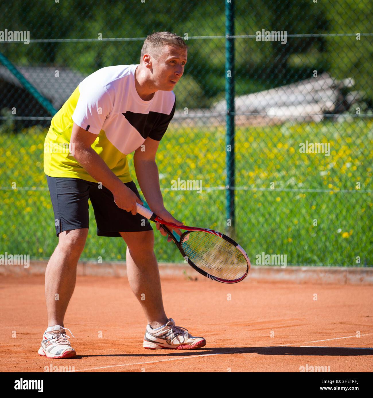 Der Tennisspieler wartet auf dem Sandplatz auf den Ball Stockfoto